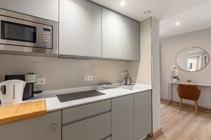 A modern kitchen with a built-in microwave, coffee maker, and kettle. - A1 Apartment with Cathedral Views – Historic Center of Seville & Pool (Seville)