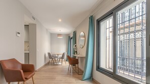 Een modern interieur met een eethoek, een bank en een groot raam met uitzicht.