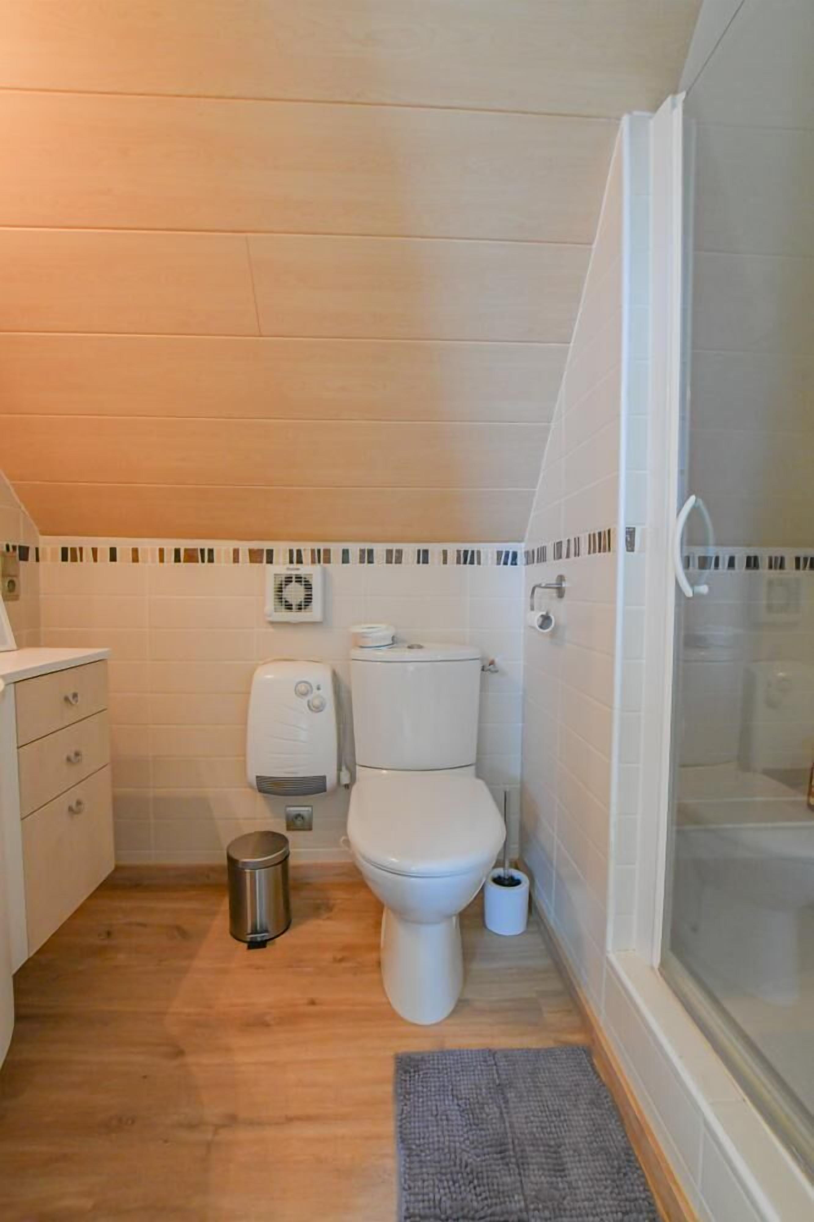A compact bathroom with a toilet, bidet, and a shower enclosure.