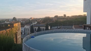 Une piscine avec vue sur un quartier résidentiel et une colline en arrière-plan.