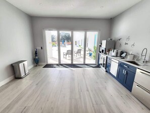 A modern kitchen with a sliding glass door leading to an outdoor patio area. - Tranquil Retreat, Resort Pool, Sauna, Arcade (Lutz)