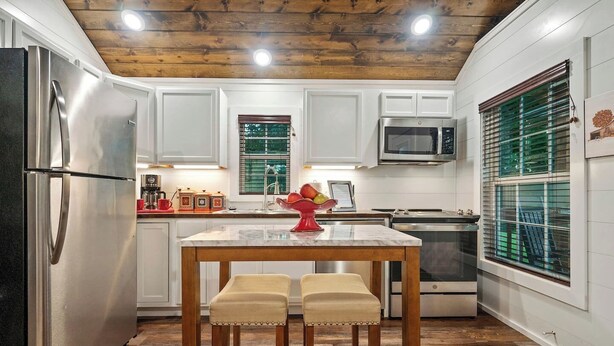 A kitchen with white cabinets, stainless steel appliances, a wooden ceiling, and a marble countertop. - Private Ranch - 27 Acres - Two Private, Secluded Cabins (Broken Bow)