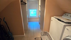 A laundry room with a washing machine, a dryer, and a window with a view of the outside. - Lakes Region Family Getaway& Pet Friendly (Belmont)