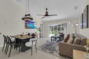 Un salon moderne avec un canapé, une table basse et un coin repas.