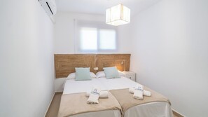 A hotel room with a double bed, two bedside tables, a nightstand, a hanging light fixture, and a window. - Villa Hop House Frigiliana by Ruralidays (Málaga)