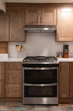 A kitchen with a stainless steel stove, double oven, wooden cabinets, and a white countertop. - 8-Acre Retreat with Trails, 7 Min to Killington (Plymouth)