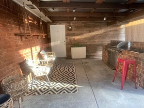 A compact kitchen with a grill, a door, and a patterned rug. - Modern 4BR Retreat Near Little Saigon Fast Wi-Fi & Free Parking (Houston)