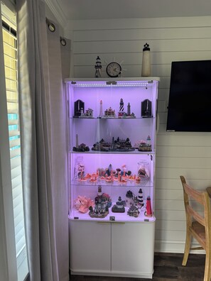Ein weißes Schranksystem mit mehreren Regalen, gefüllt mit verschiedenen Miniaturen und Objekten.