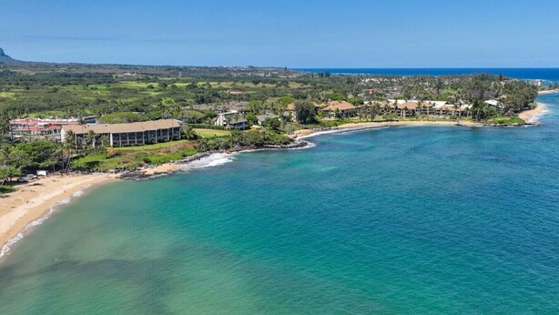 A coastal property with a beach, ocean view, and residential buildings.