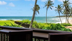 A view of a beach with palm trees and ocean waves.