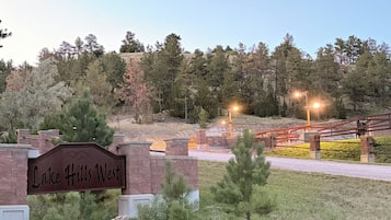 A sign for Lake Hills West with a brick wall and a grassy area in front.
