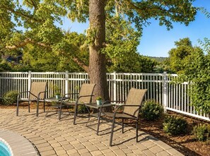 An outdoor patio with a pool, surrounded by a white fence and trees. - Off-Grid Hidden Oaks Private Retreat (Atascadero)