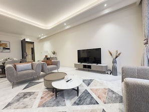 A modern living room with a sofa, coffee table, and TV.