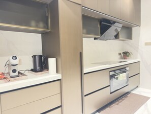 A modern kitchen with built-in appliances, a countertop, and a small oven.