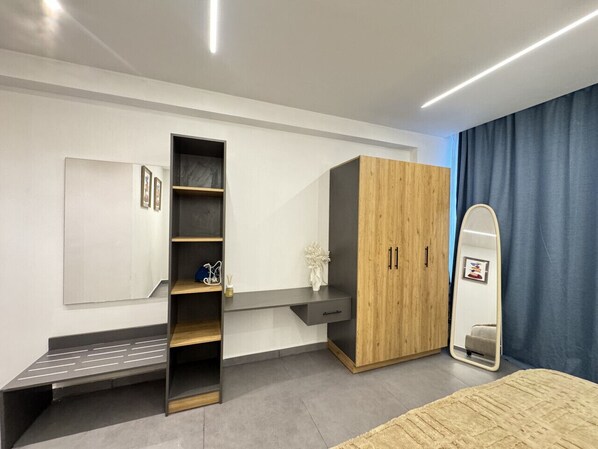A modern bedroom with a built-in wardrobe, a bedside table, a mirror, and a bed.