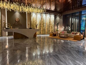 A modern reception area with a marble floor, a reception desk, and a seating area with sofas and a coffee table. - Grand Résidence, 2 Bedrooms Stylish Apartment  Kinshasa (Gombe) – Galerie Lafontaine (Kinshasa)