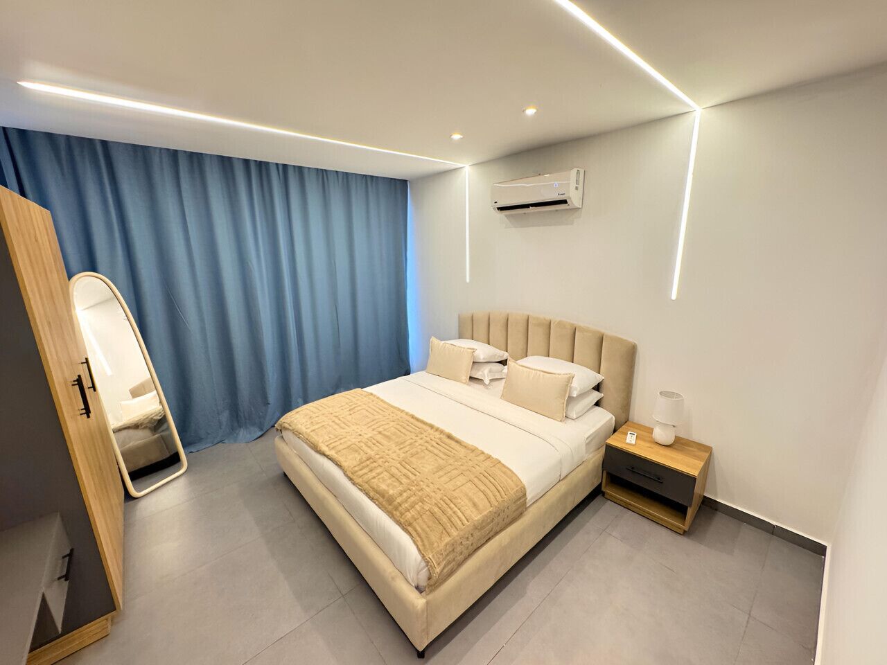 Une chambre à coucher moderne, équipée d’un lit, d’une table de chevet et d’un appareil de climatisation.