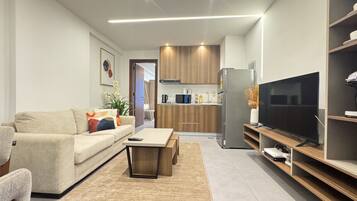 A modern living room with a sofa, coffee table, and TV stand.