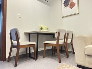 A dining area with a table and four chairs, a vase with flowers, and a framed picture on the wall. - Modern & Cosy Oasis in Central Gombe – Pool, Spa & (Kinshasa)