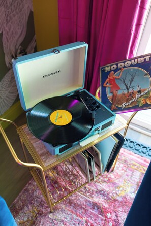 En vinylpladespiller med en plade, stående på et lille bord.