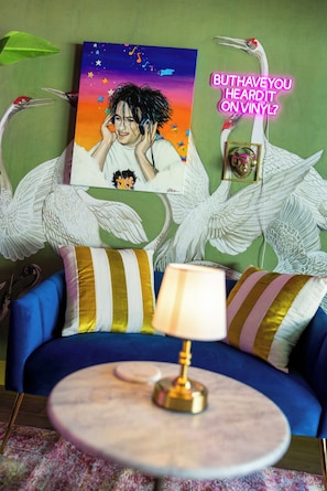 A room with a blue sofa, a round table with a lamp, and a painting on the wall. - The Gilded Bungalow • Walk to Town Green • Hot Tub • Firepit • Pink Kitchen (Windsor)