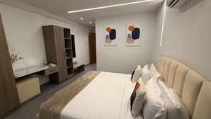 A modern hotel room with a bed, a desk, and a wardrobe. - Cozy 1 bedroom Studio Apartment with Pool in Gombe (Kinshasa)