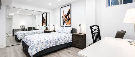 Un dormitorio moderno con dos camas, un escritorio y una silla.