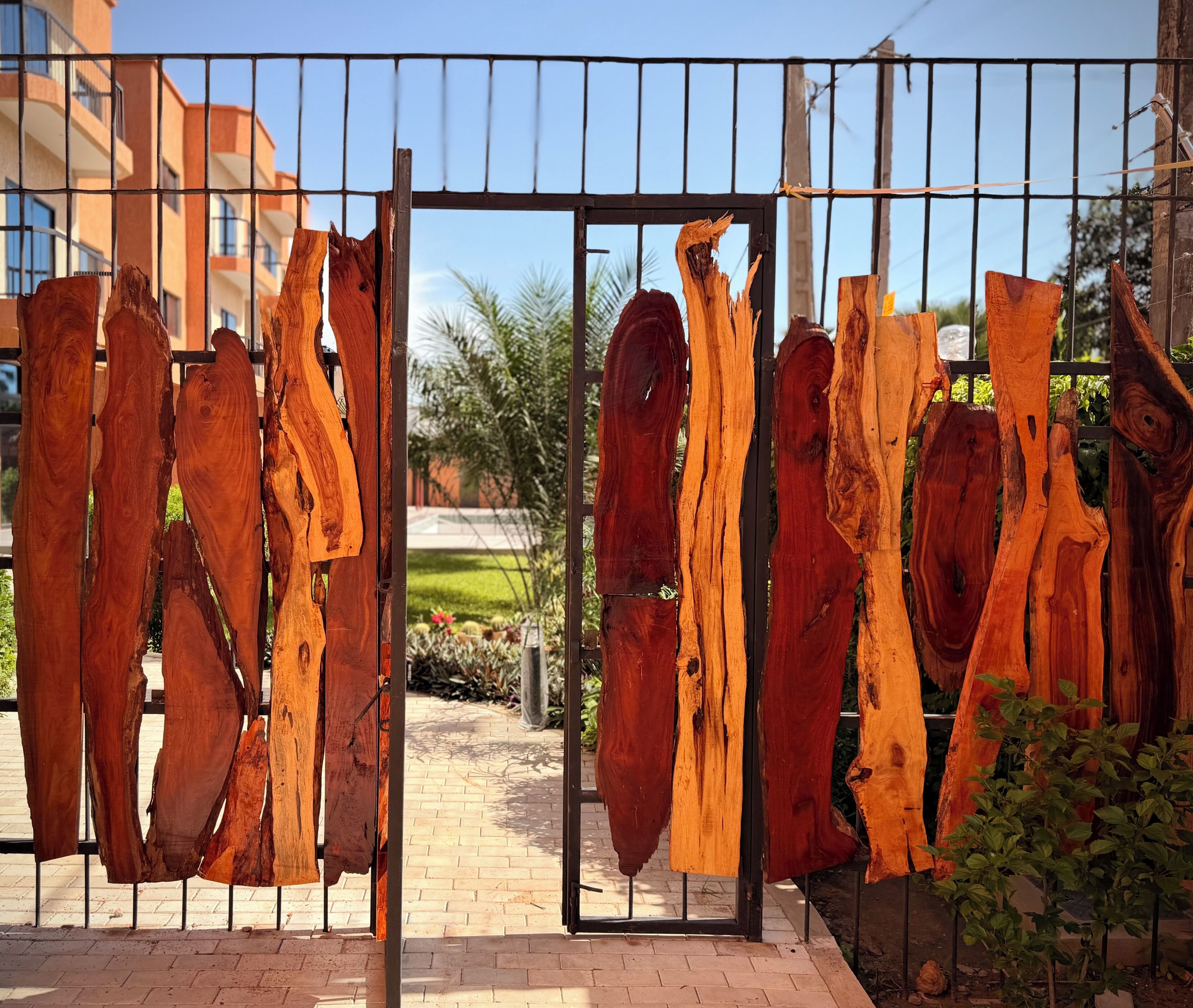 A metal gate with large wooden planks hanging on it.