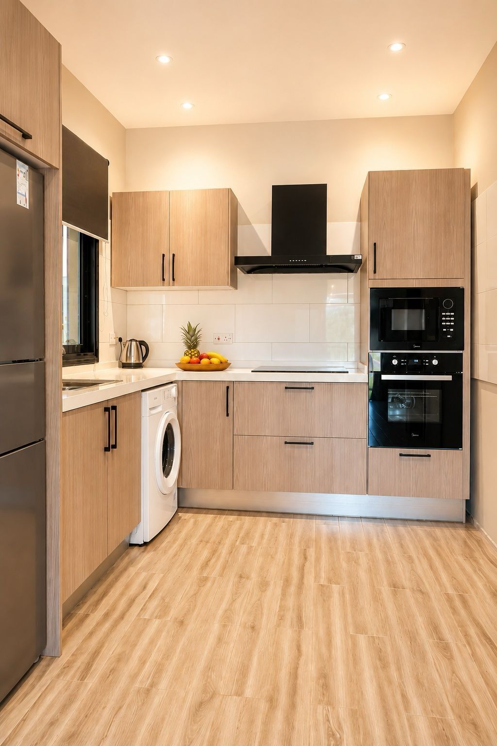 A modern kitchen with stainless steel appliances, wooden cabinets, and a built-in washing machine.