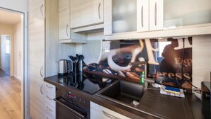 Eine moderne Küche mit Edelstahlgeräten, Holzschränken und einem großen Fenster.