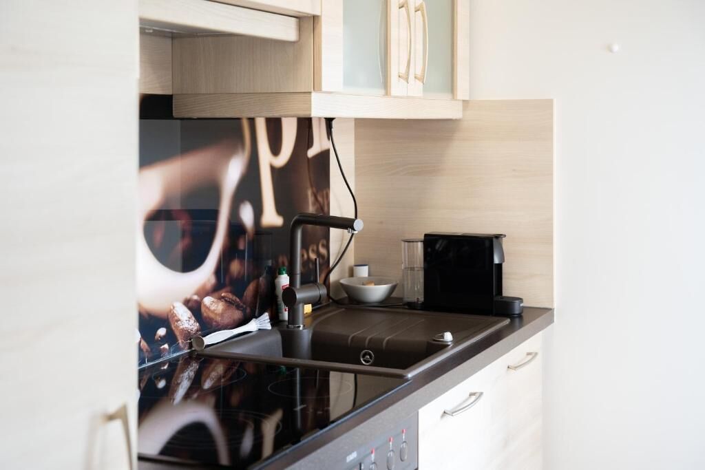 A kitchen with a coffee maker, a bowl, and a cabinet.