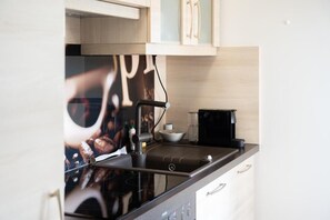 Eine Küche mit einer Kaffeemaschine, einer Schüssel und einem Schrank.