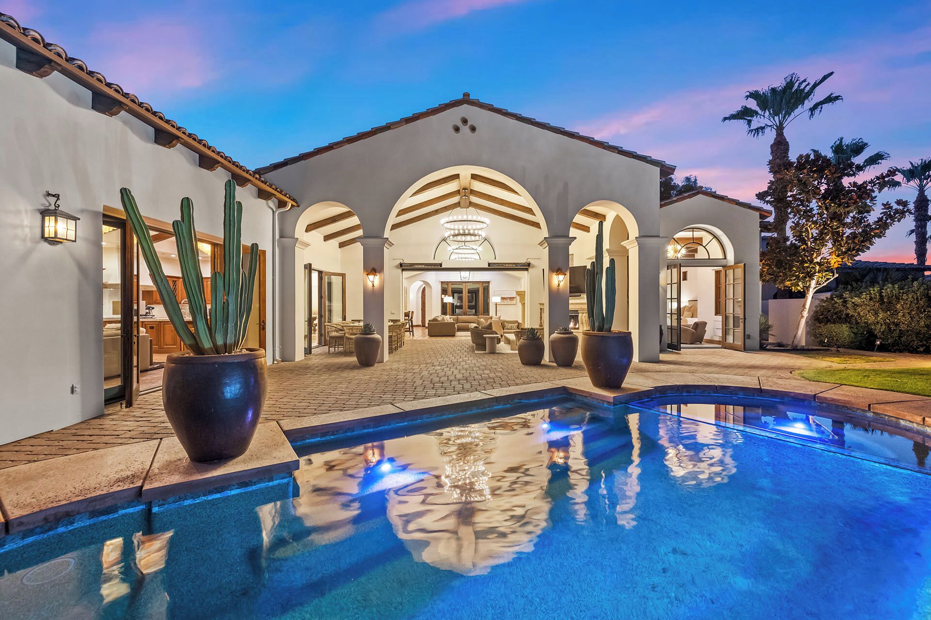 Zona de piscina con vista despejada, un patio y un edificio con arcos.