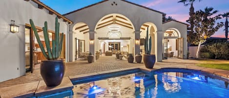 Zona de piscina con vista despejada, un patio y un edificio con arcos.