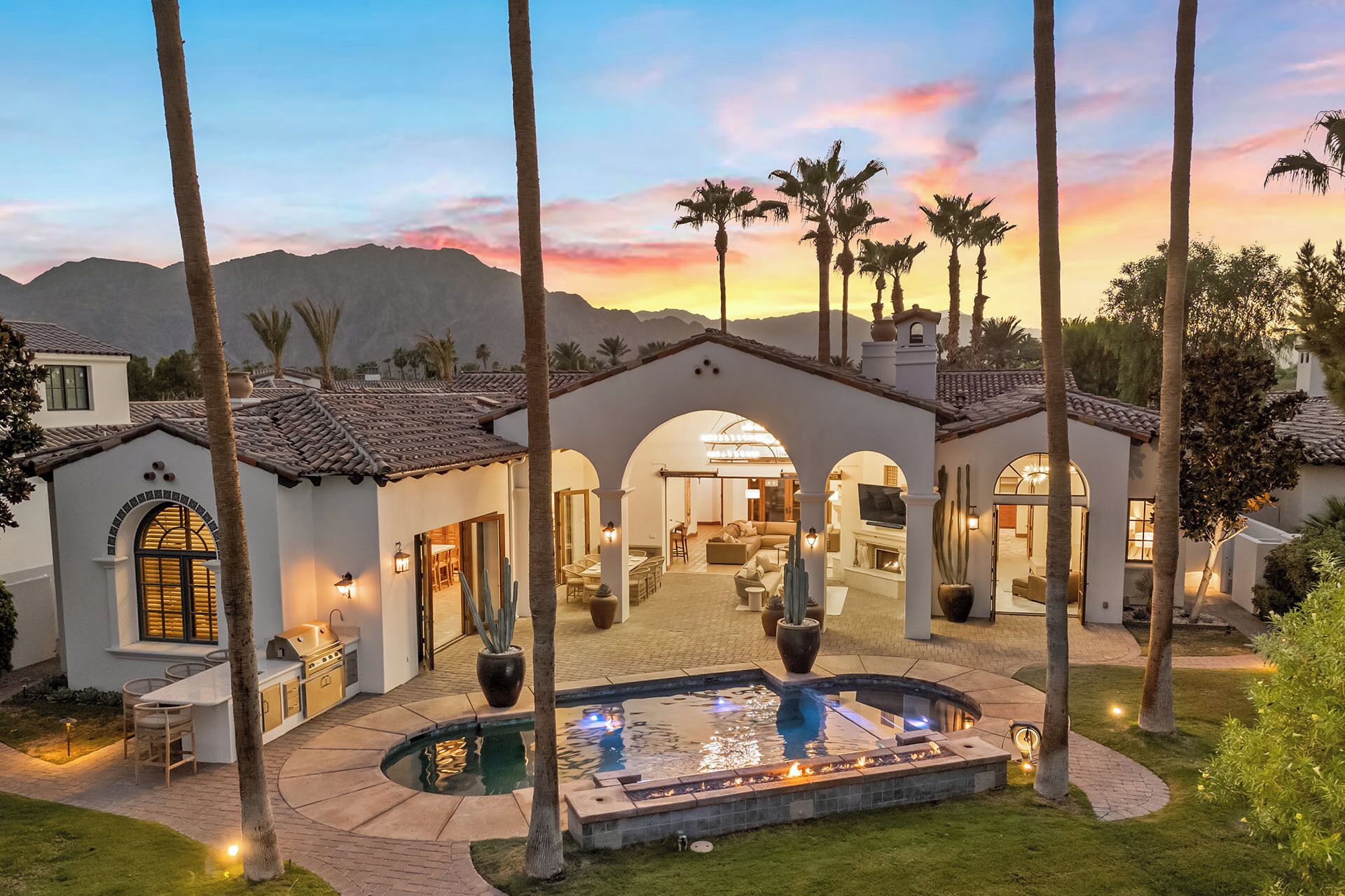 A residential property with a pool, outdoor seating, and a patio area.