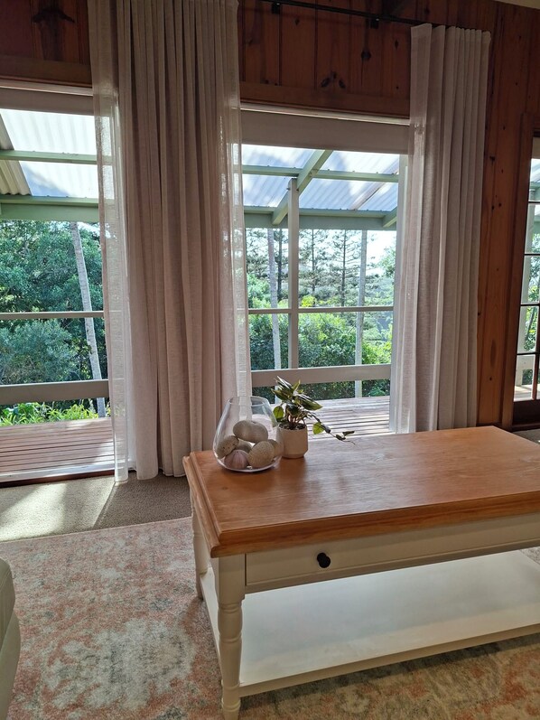 A room with a wooden table, a bench, and a window with curtains.