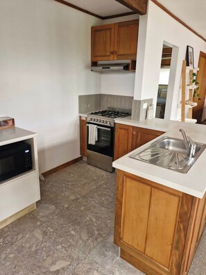 A kitchen with a built-in oven, a microwave, and a sink.