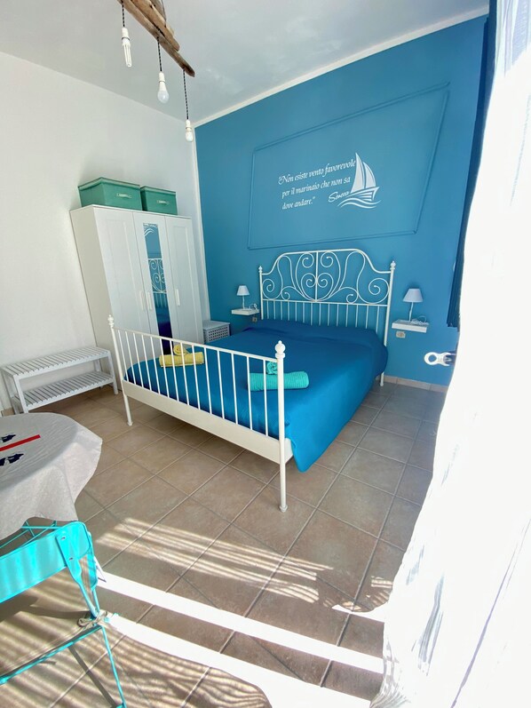 A bedroom with a bed, wardrobe, and a wall with a quote.
