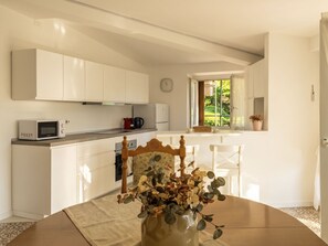A modern kitchen with white cabinets, a microwave, and a coffee maker on the counter. - Balconi sulla Spiaggia by Interhome (Bellano)