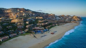 A coastal residential area with beachfront properties, a swimming pool, and a view of the ocean. - Junior Ocean View Suite with Sunset Views in Cabo (Cabo San Lucas)