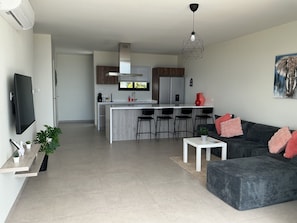 A modern living space with a kitchen, dining area, and a seating area with a sofa and ottoman. - Nice View Apt 8 - 2-BR apartment with AC on spectacular Mahuma hill (Willemstad)