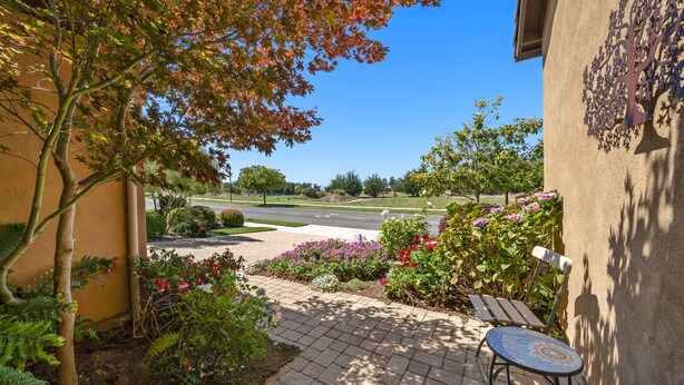 A patio area with a table and benches, surrounded by a garden with various plants and flowers. - Relaxing getaway next to award winning golf course (Nipomo)