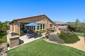 A house with a patio, outdoor furniture, and a well-maintained garden. - Relaxing getaway next to award winning golf course (Nipomo)
