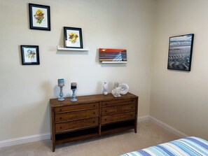 A bedroom with a bed, a dresser, and wall art. - Relaxing getaway next to award winning golf course (Nipomo)
