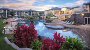 Ein Resort mit Schwimmbad, Liegestühlen und einem angelegten Garten.