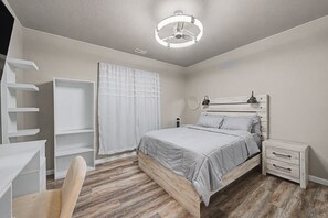 A bedroom with a bed, bedside tables, a wardrobe, and a desk. - Lux Retreat Family-Friendly Near USAFA, Parks (Colorado Springs)