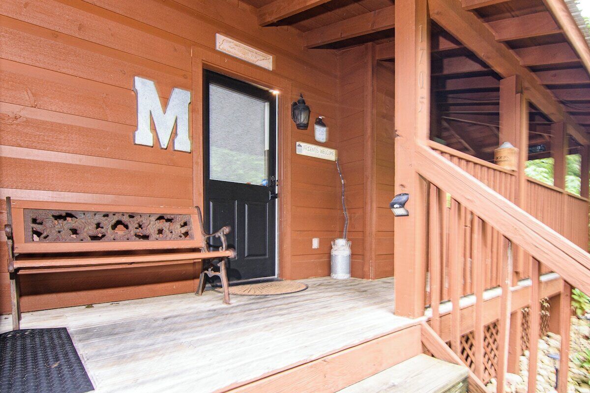 Un bâtiment en bois avec un grand panneau en forme de « M », un banc et une pancarte indiquant « Bienvenue ».