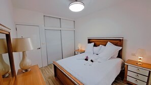 A hotel room with a bed, bedside tables, a mirror, and a wardrobe. - COSTA DE LUXE (Bayahíbe)