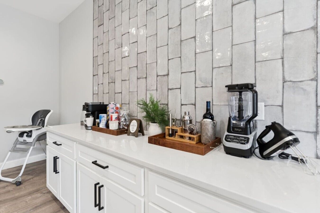 A kitchen with a white countertop, a coffee machine, a blender, and a toaster.