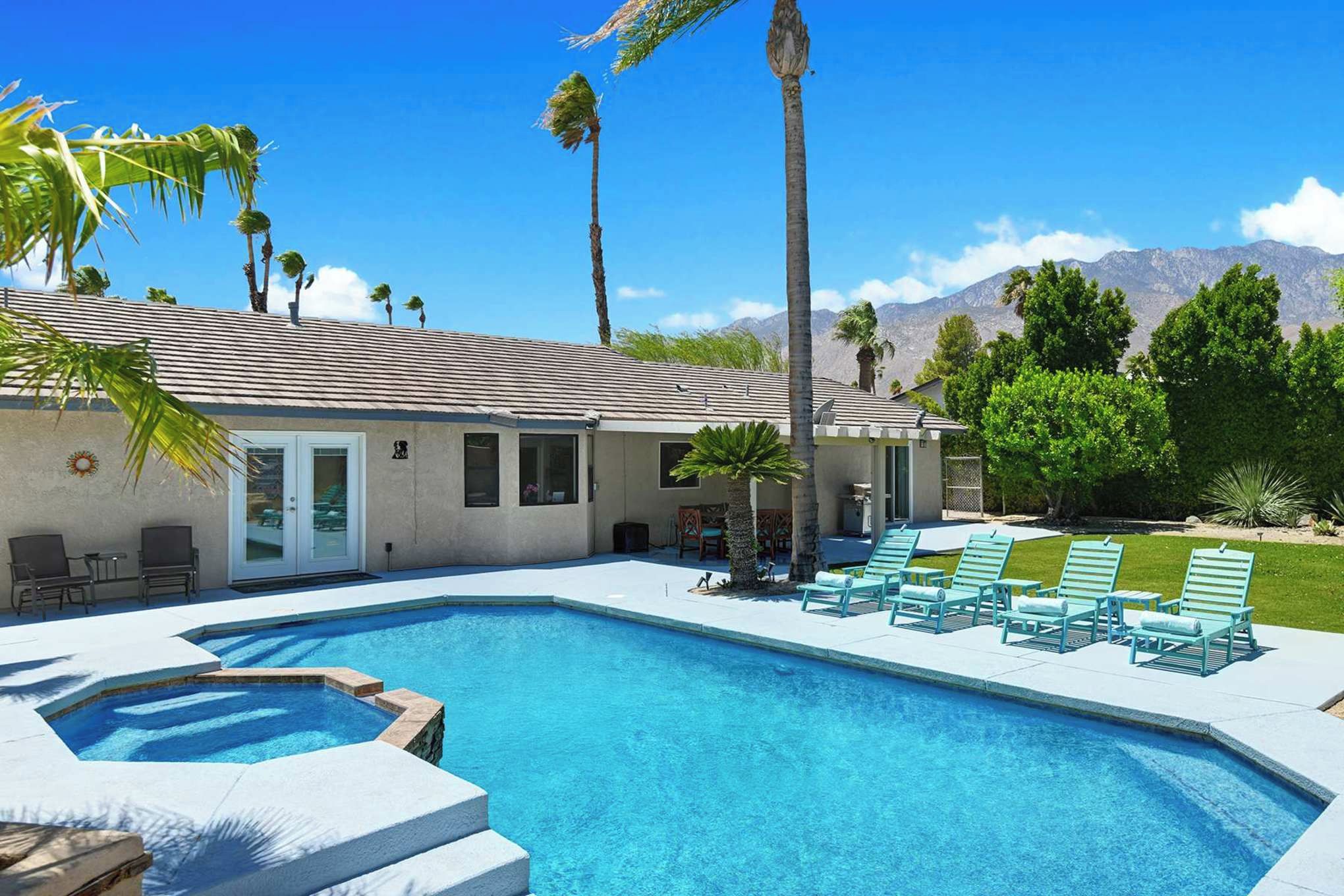 Property exterior with pool, hot tub, and mountain backdrop—a perfect desert oasis setting for your getaway.